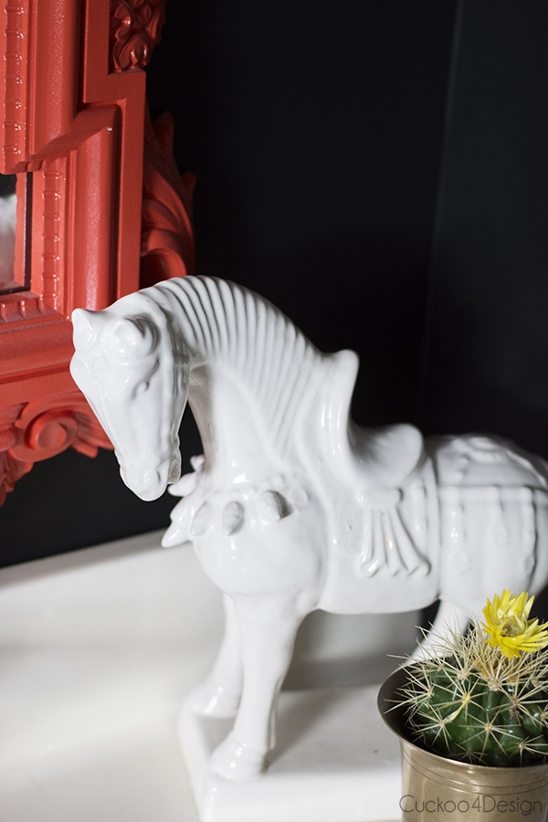 ceramic horse on vanity with black bathroom walls