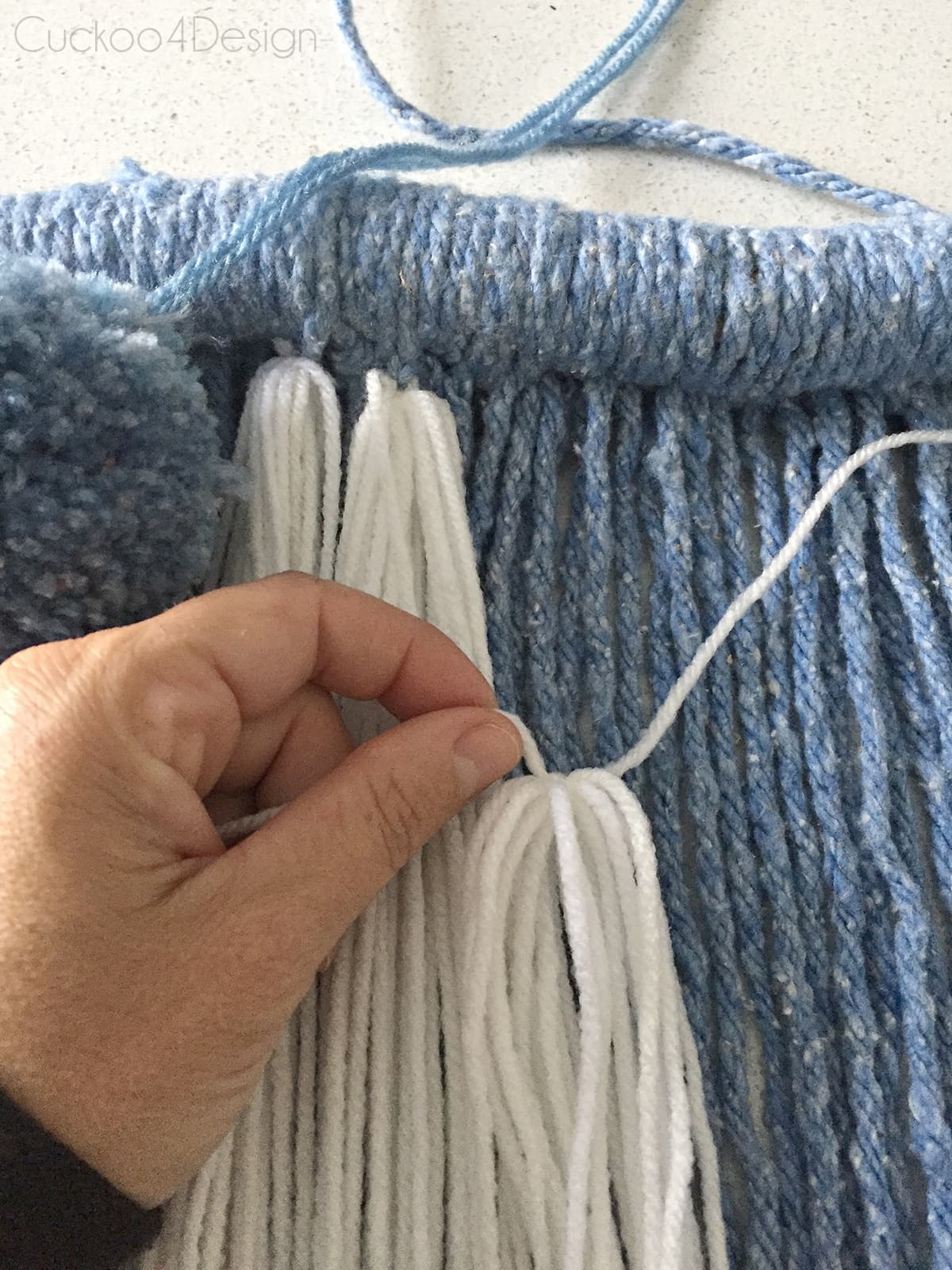 tying wool detail to mop head yarn wall hanging