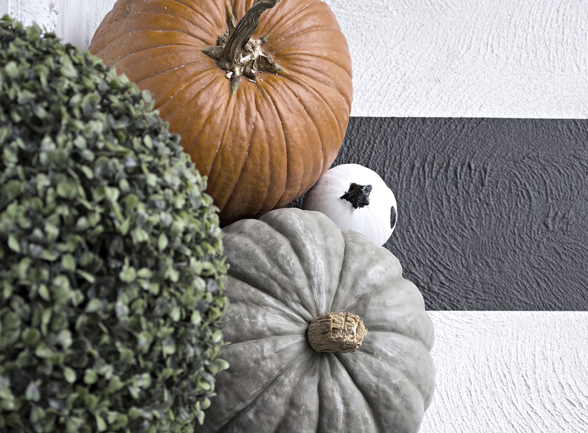 pumpkins on black and white striped front porch