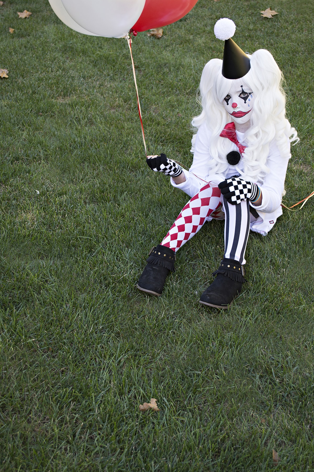 sitting on grass in Harlequin costume