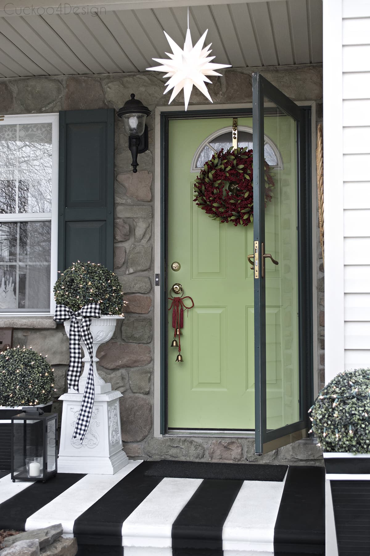 black and white striped porch with lime green door and red wreath
