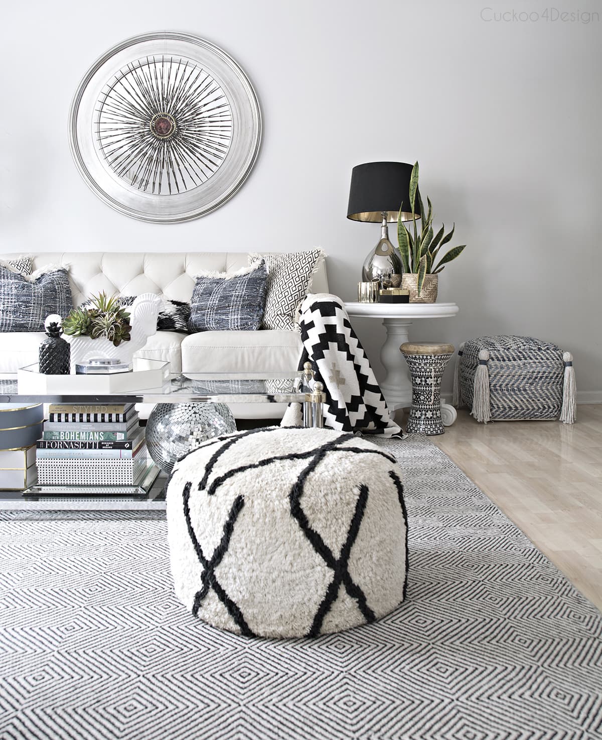 view of living room with denim decor and black and white accents with finished tassel ottoman