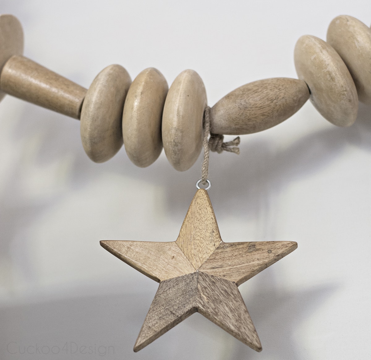 wooden star hanging on large wooden bead garland