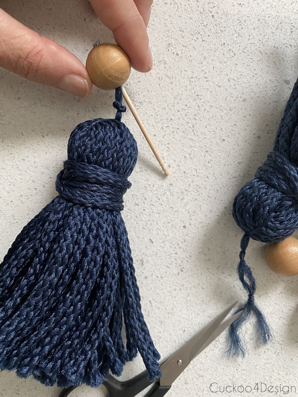 pushing yarn through bead with toothpick
