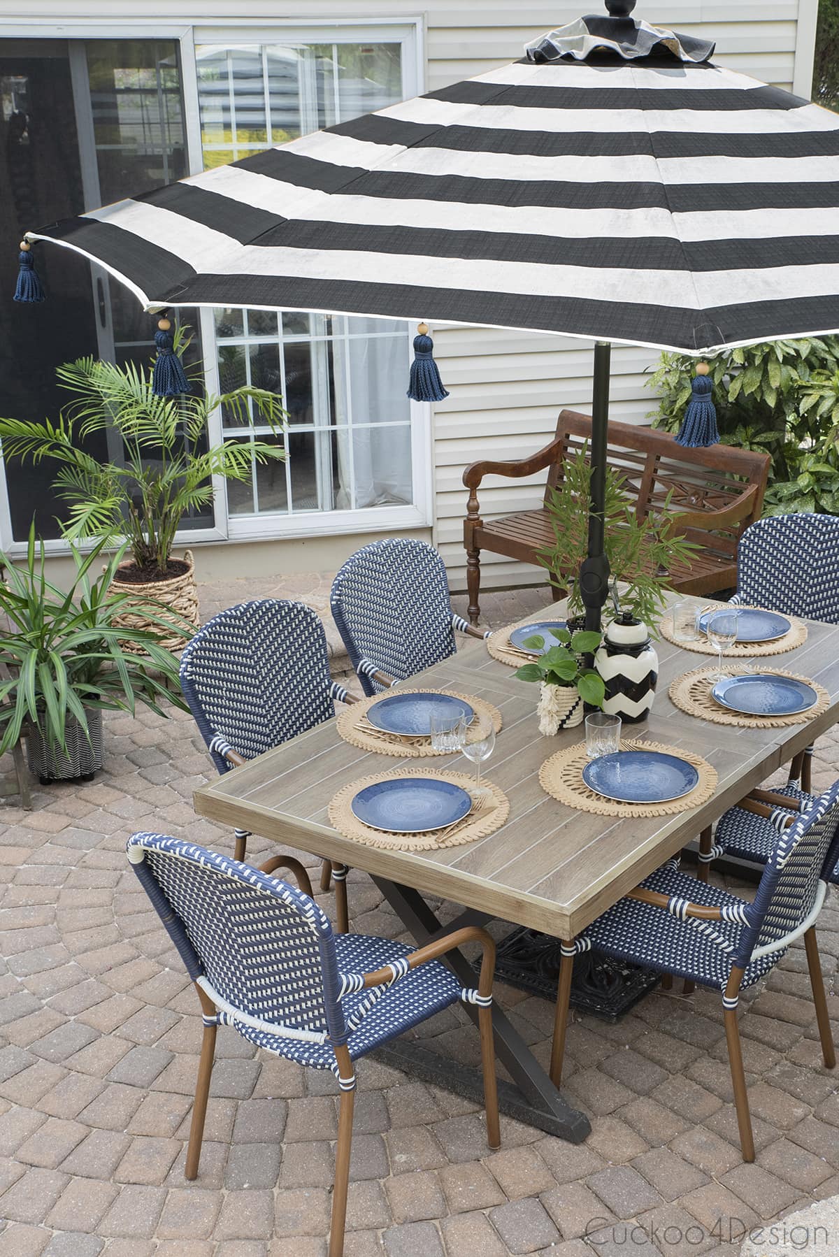 DIY tassel umbrella on patio with woven French bistro chairs