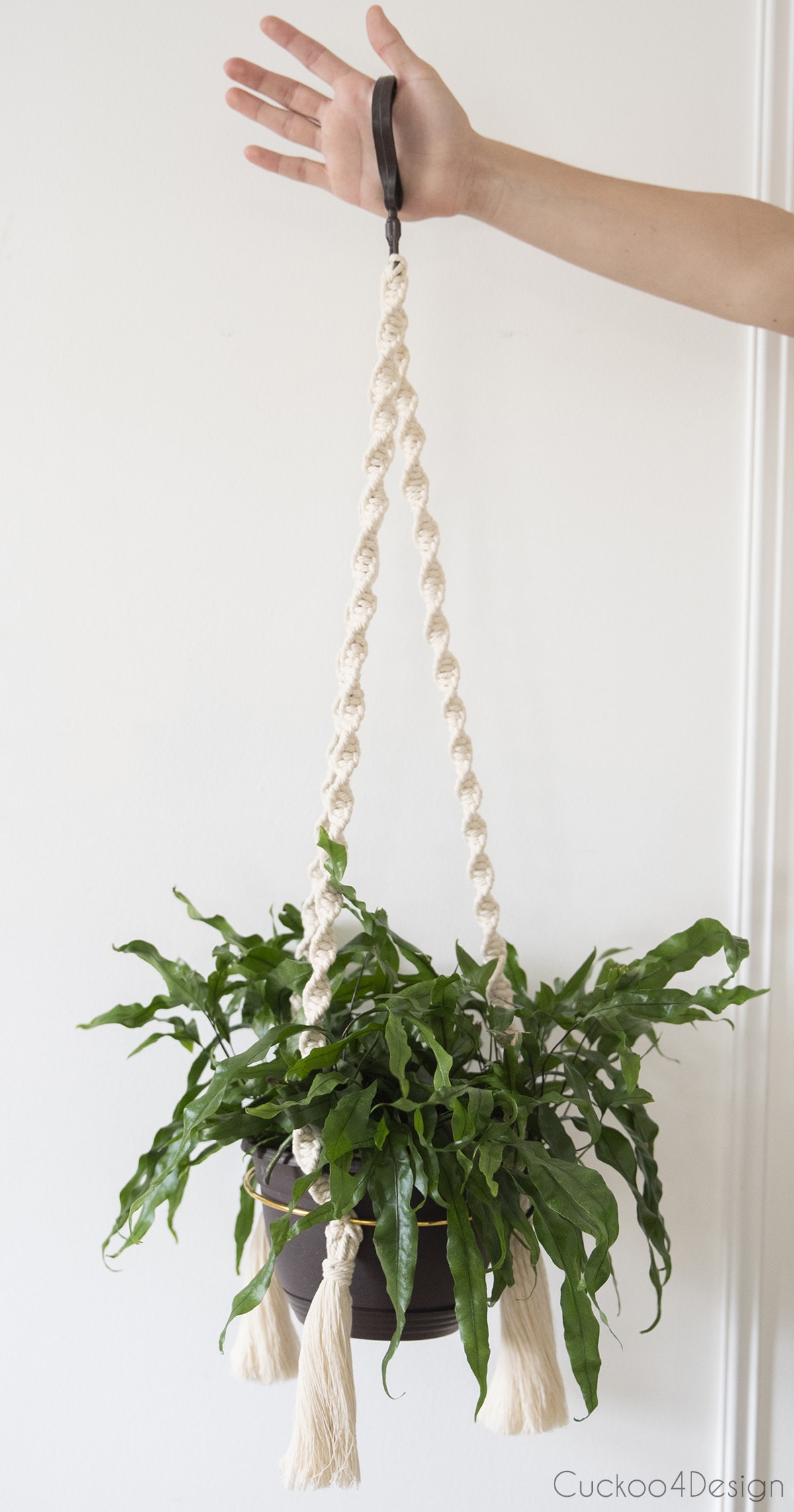 arm holding finished macrame hanging planter to show full length