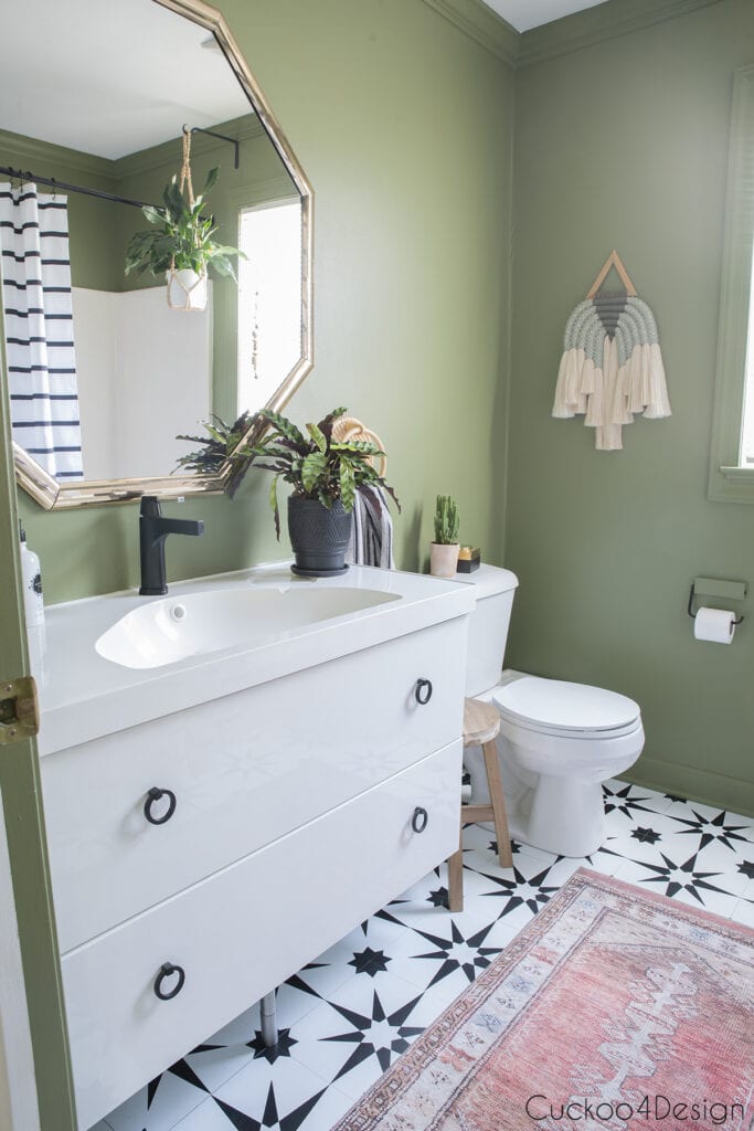 olive green bathroom with black and white peel and stick floor