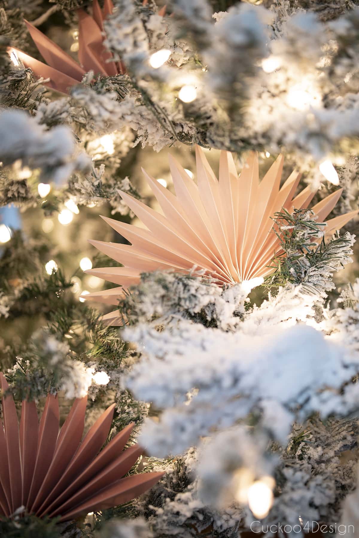 pastel faux palm leaf paper fan decorations inside flocked Christmas tree