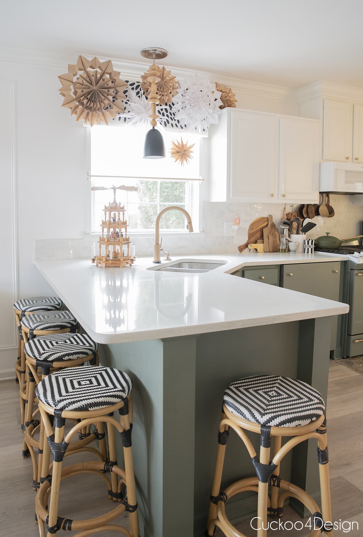 White and green kitchen with rattan counter stools