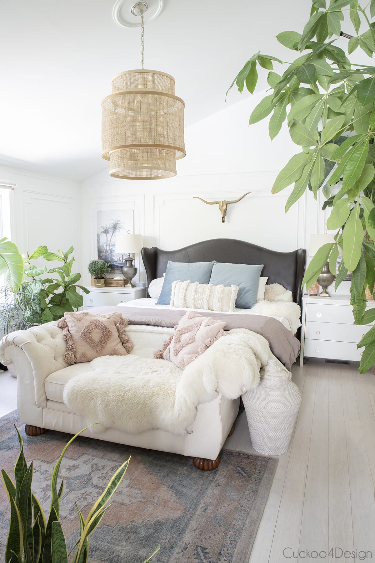 boho bedroom in neutrals, blush tones and blue accents with large cane pendant light