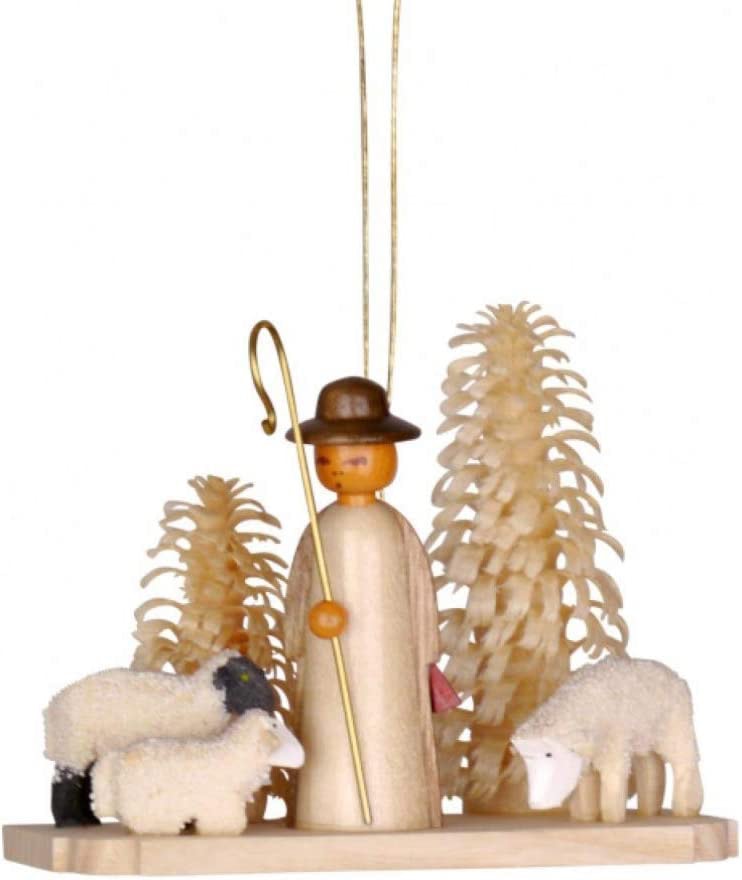 German shepherd with sheep and carved shaved pine trees