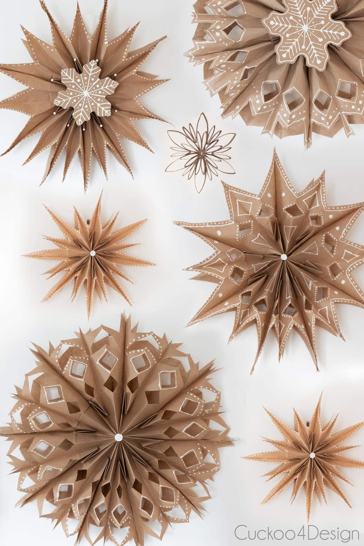 one small toilet paper roll snowflake amongst different paper bag snowflakes