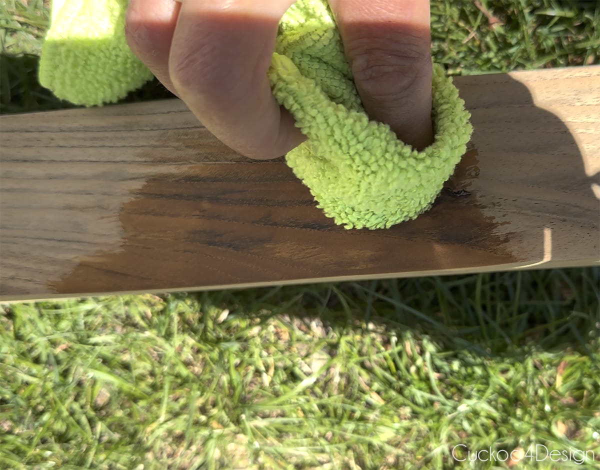 close-up of applying teak color protector with a clean rag