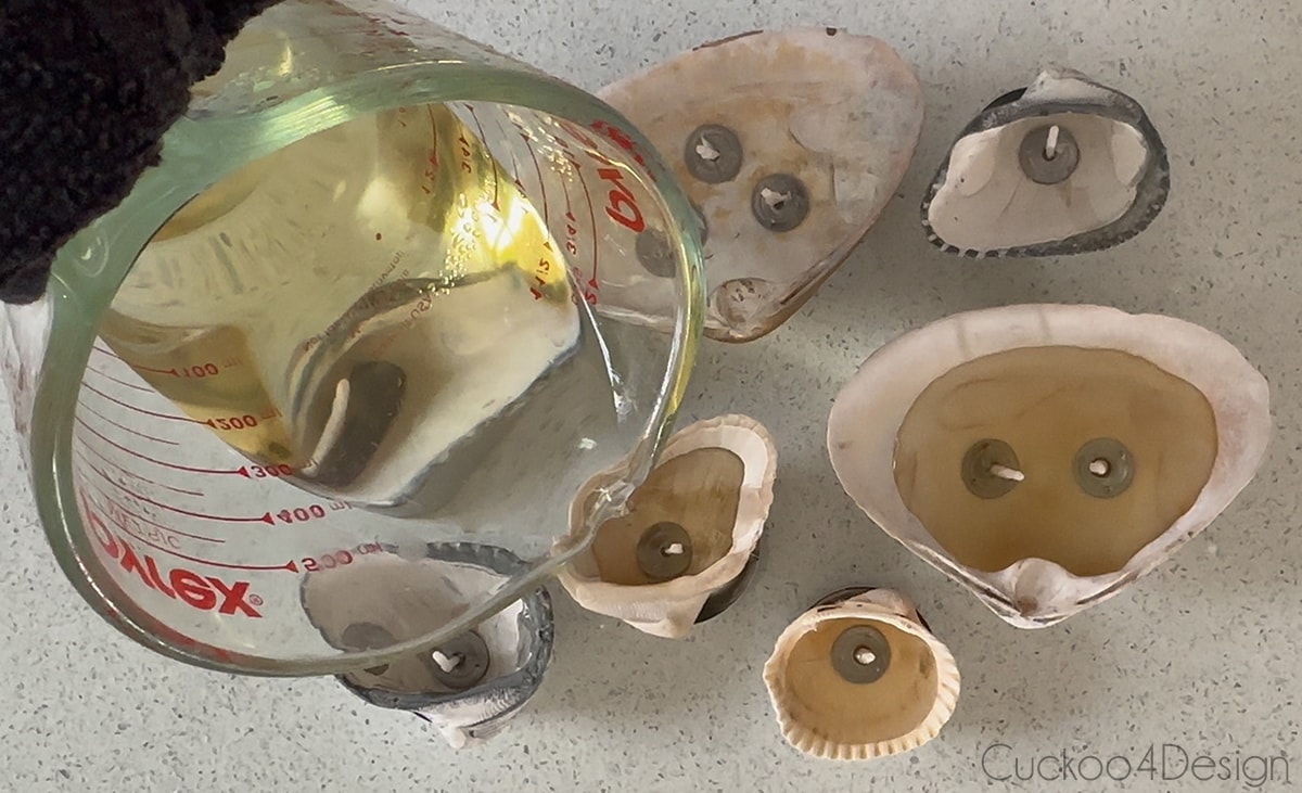 pouring the melted tea light wax into the seashells