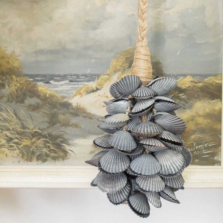 seashell tassel hanging in front of ocean painting