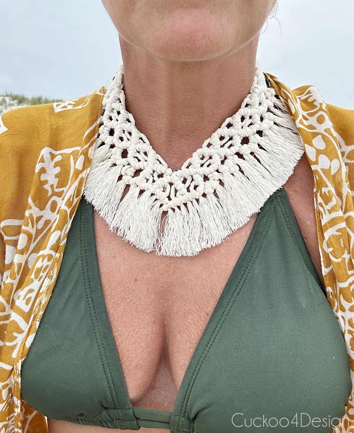 wearing an ivory macrame necklace and bikini