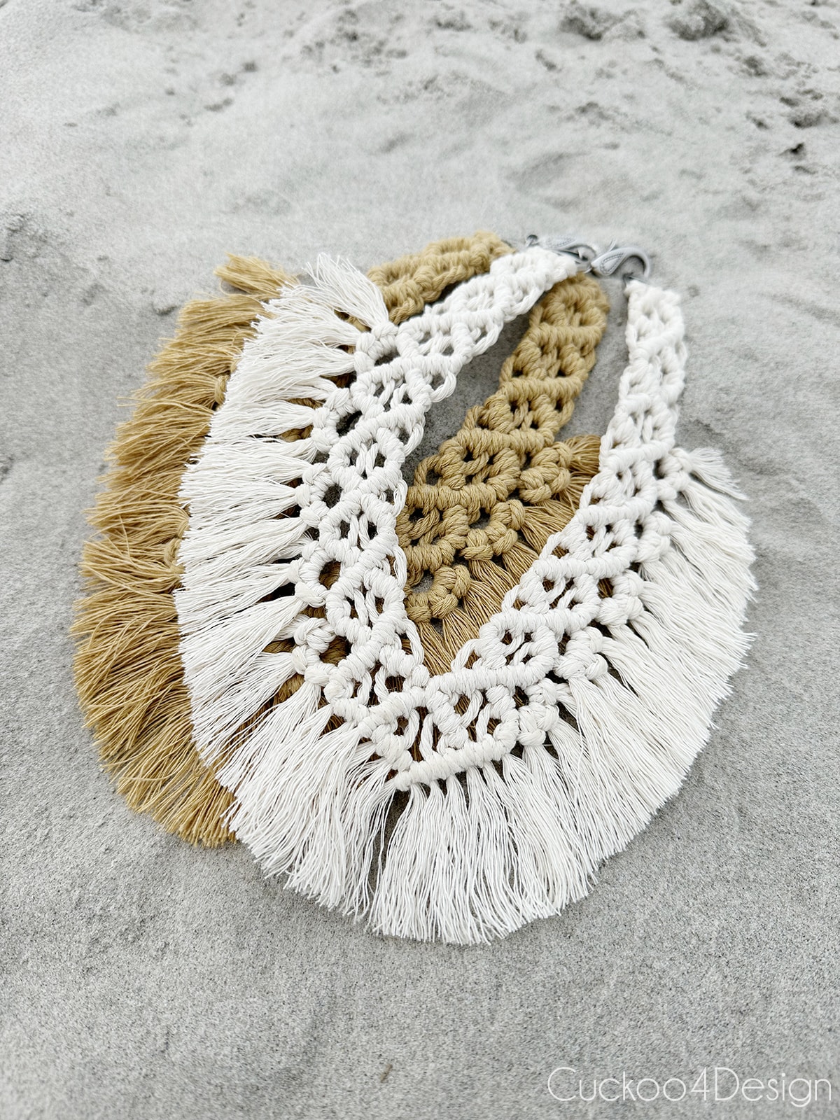 tan and ivory macrame necklace laying in the sand