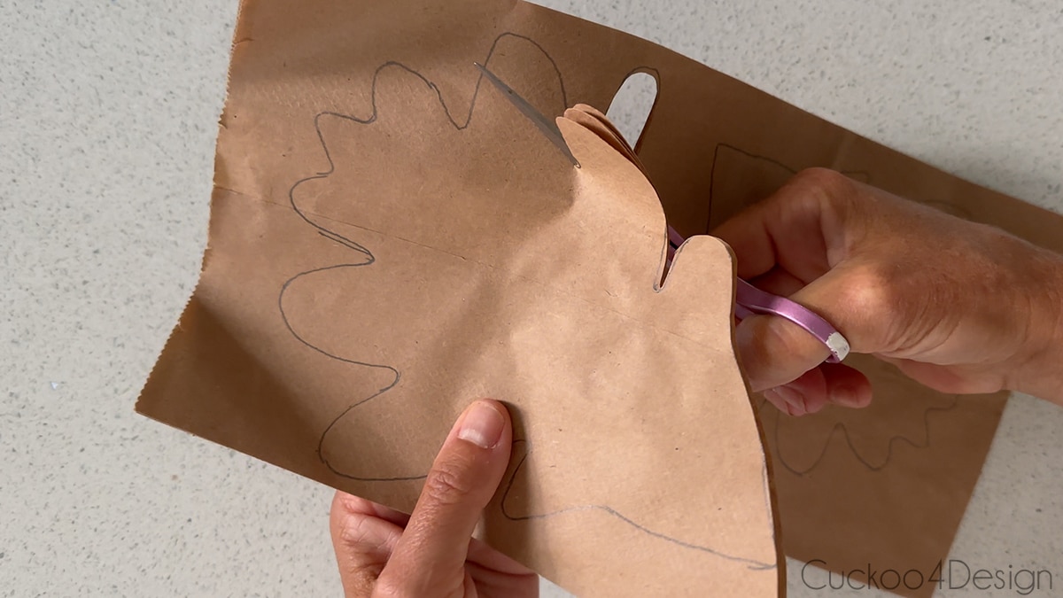 cutting out paper leaf with sharp scissors