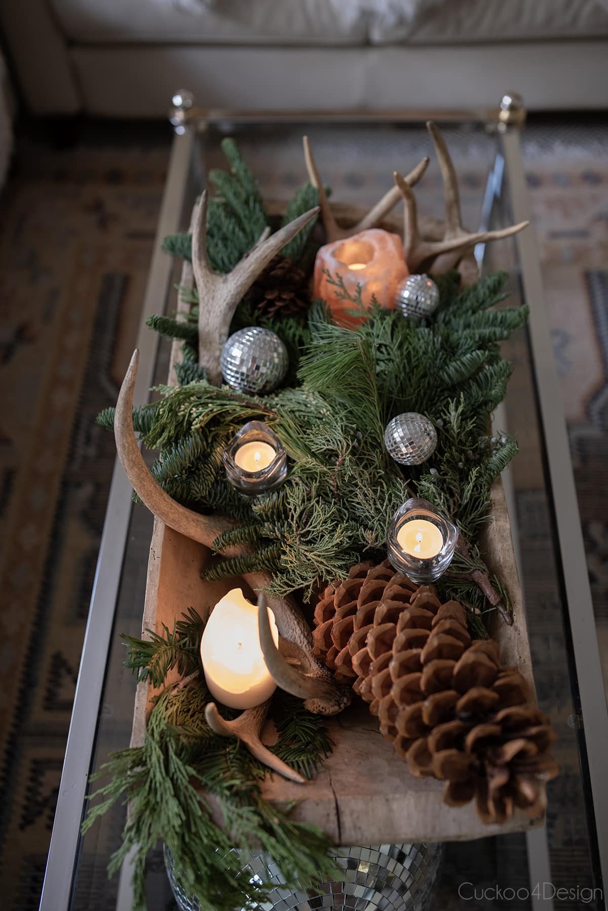 dough bowl with pine branches, pine cones, antlers, and candles