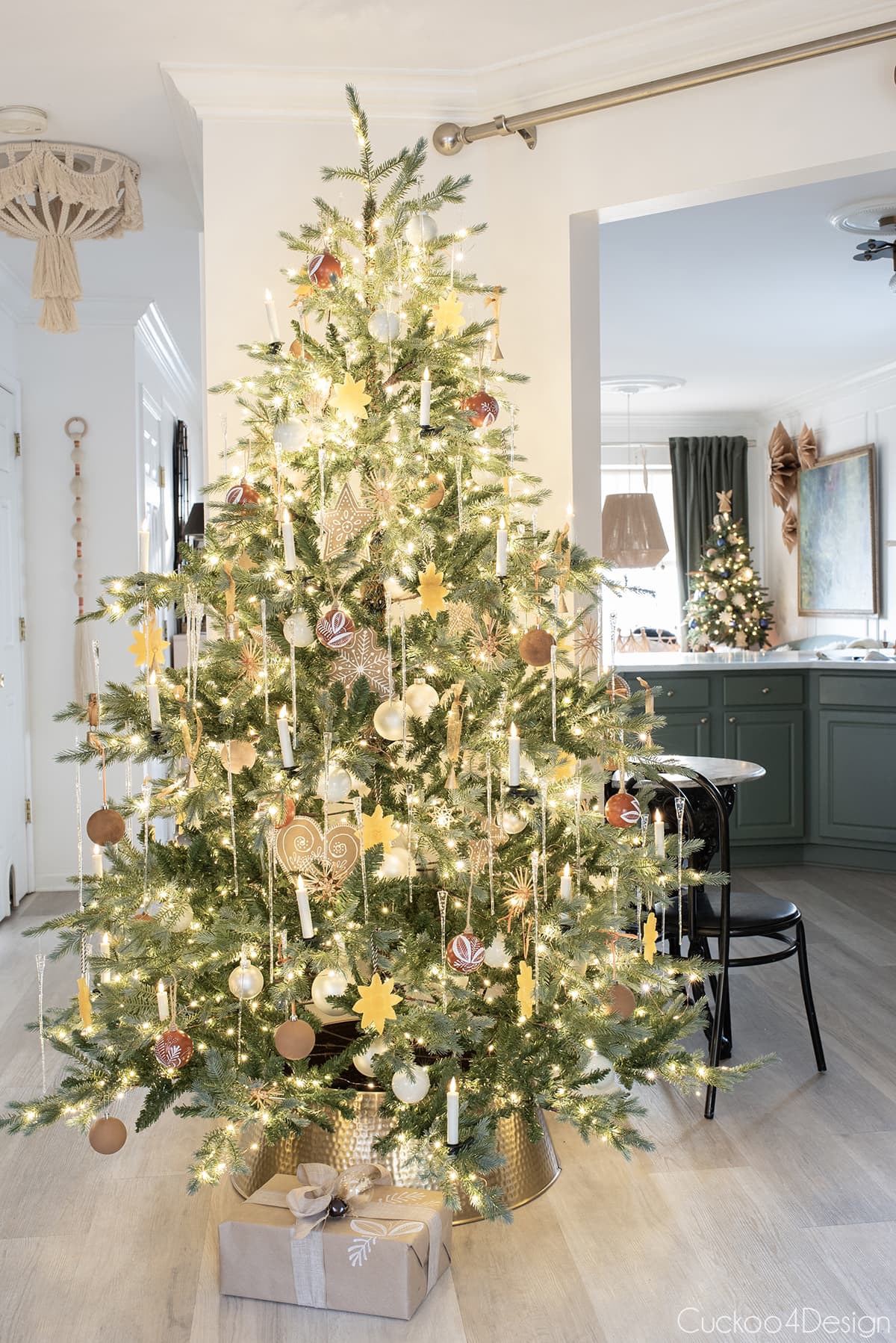 view of cheap sparse Christmas tree with kitchen behind it