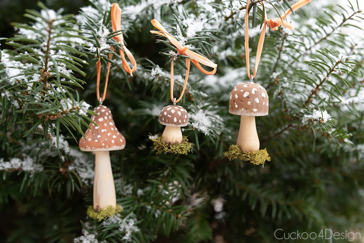 three mushroom ornaments hanging on tree in the snow