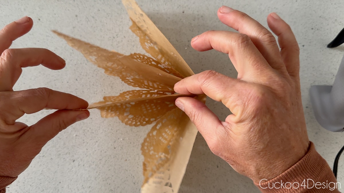 sealing the hot-glued edges of paper doily stack