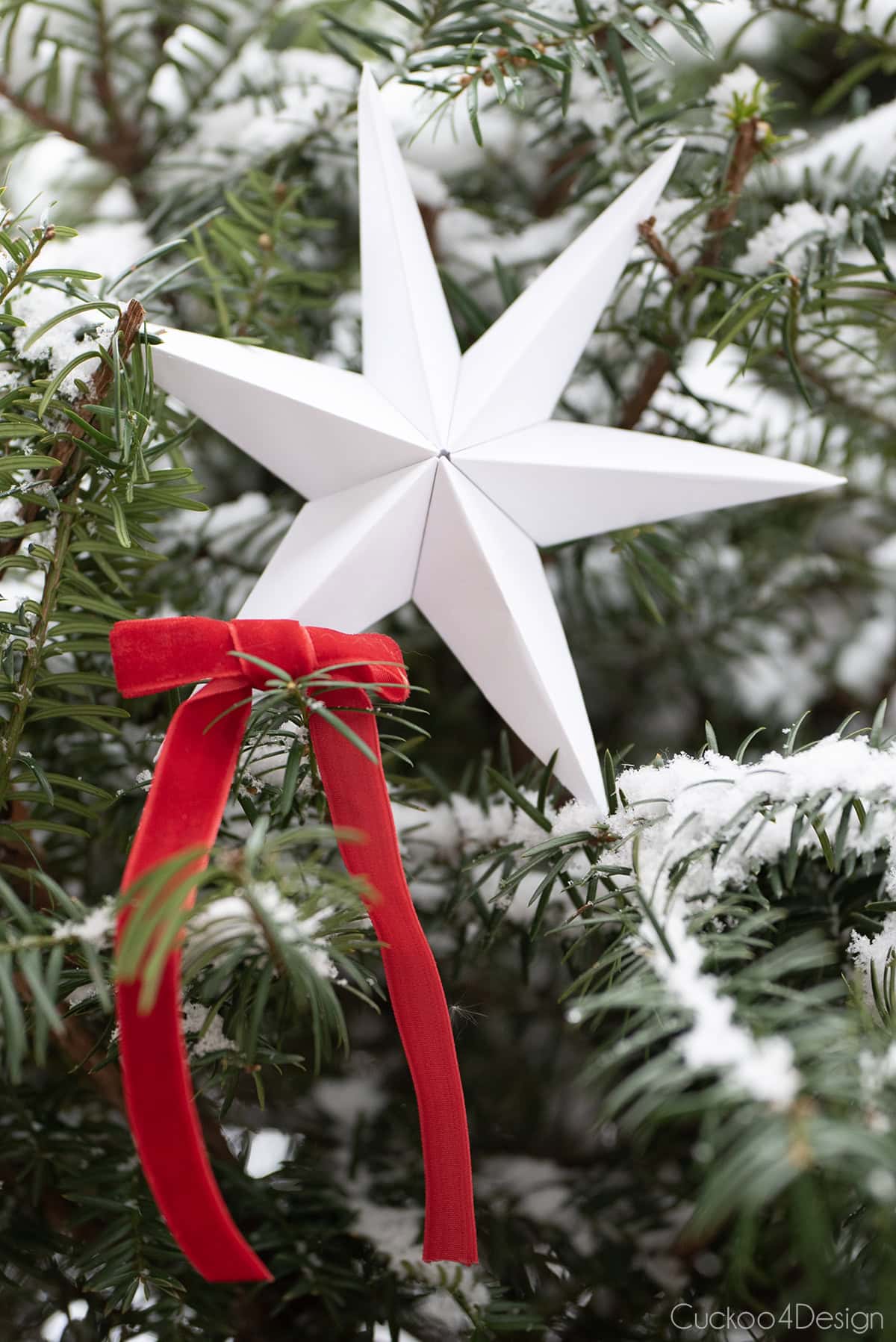 white folded paper star with red ribbon