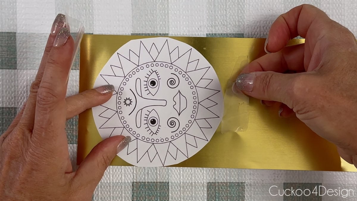 taping the ornament template to the metal sheet
