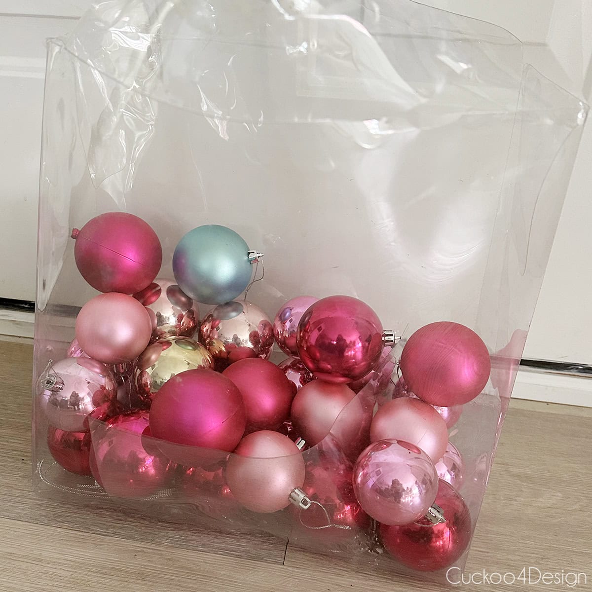 a container full of different colored plastic Christmas ball ornaments
