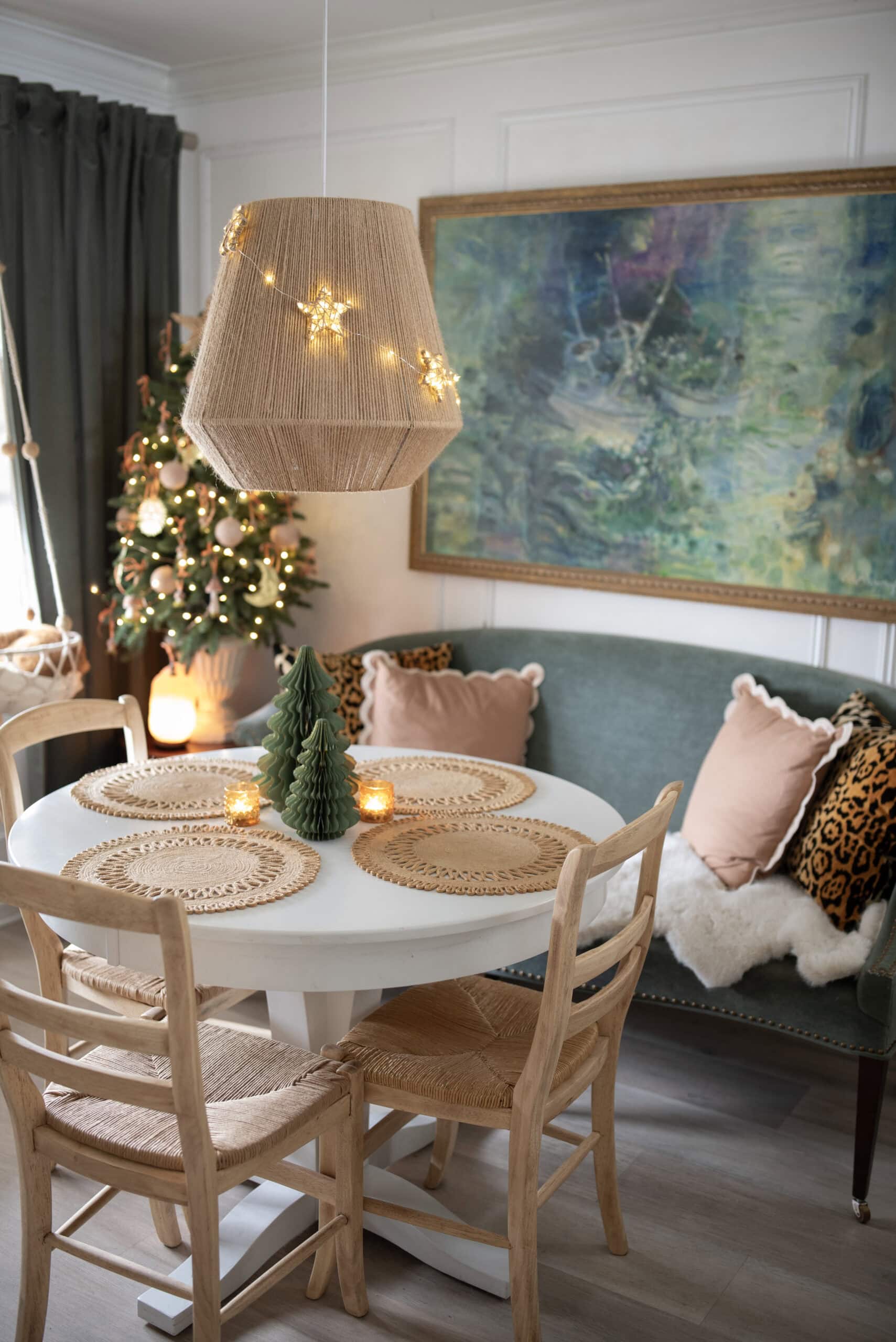 light-up yarn star ornaments on dining room pendant light with Christmas tree in the background