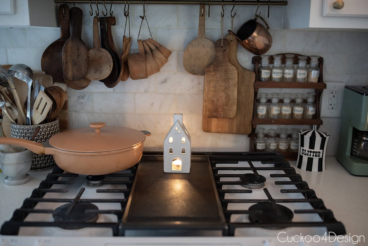 white ceramic teach light house on gas stove top