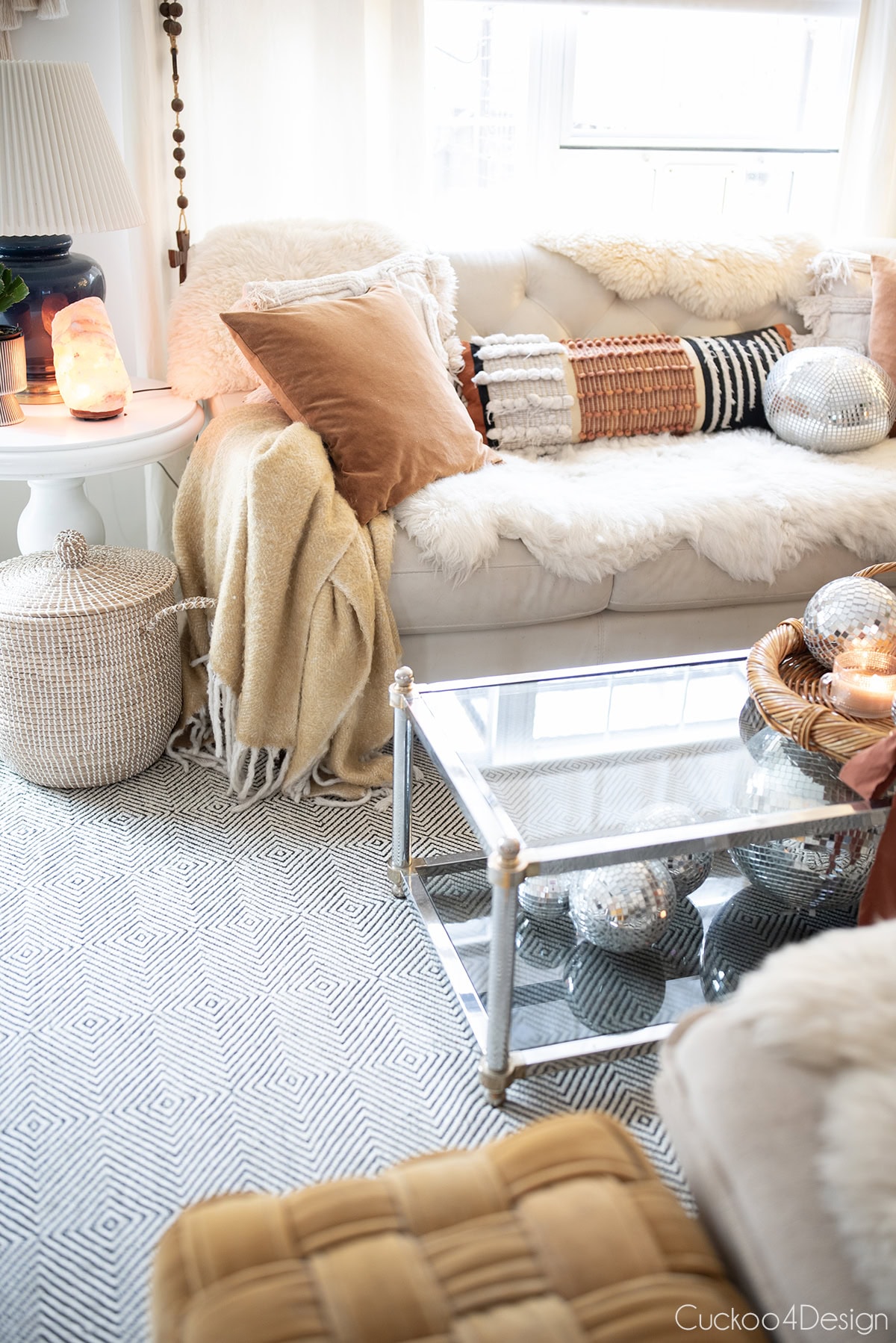 view of all the burnt orange accents in the living room including pillows, throw blanket , oranges, candle, and salt lamps