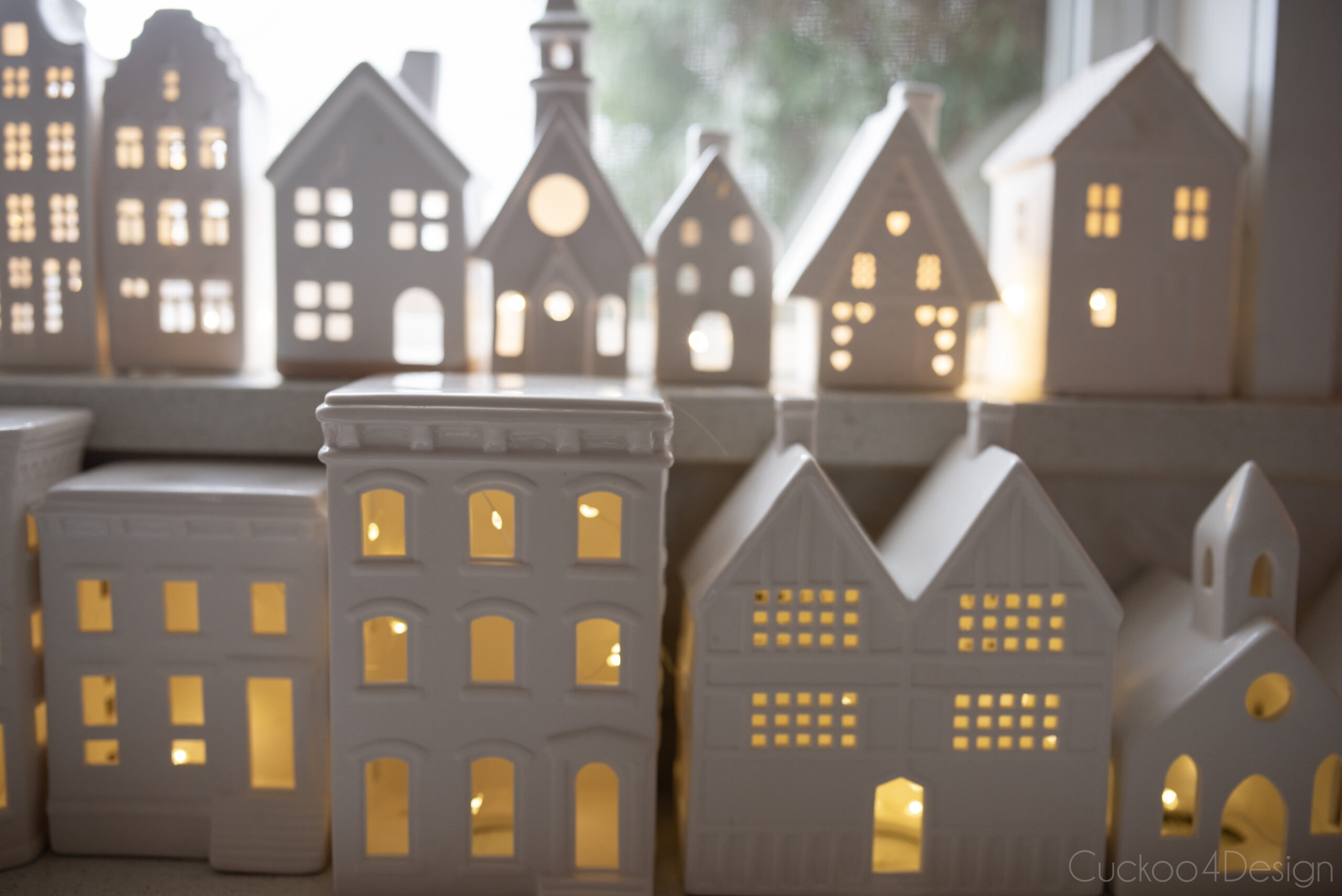 close-up of white ceramic houses lit with fairy lights