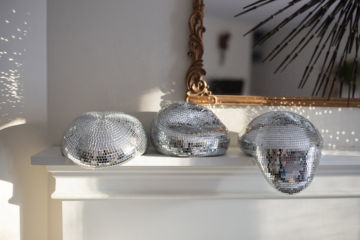 three melted disco balls on fireplace mantel