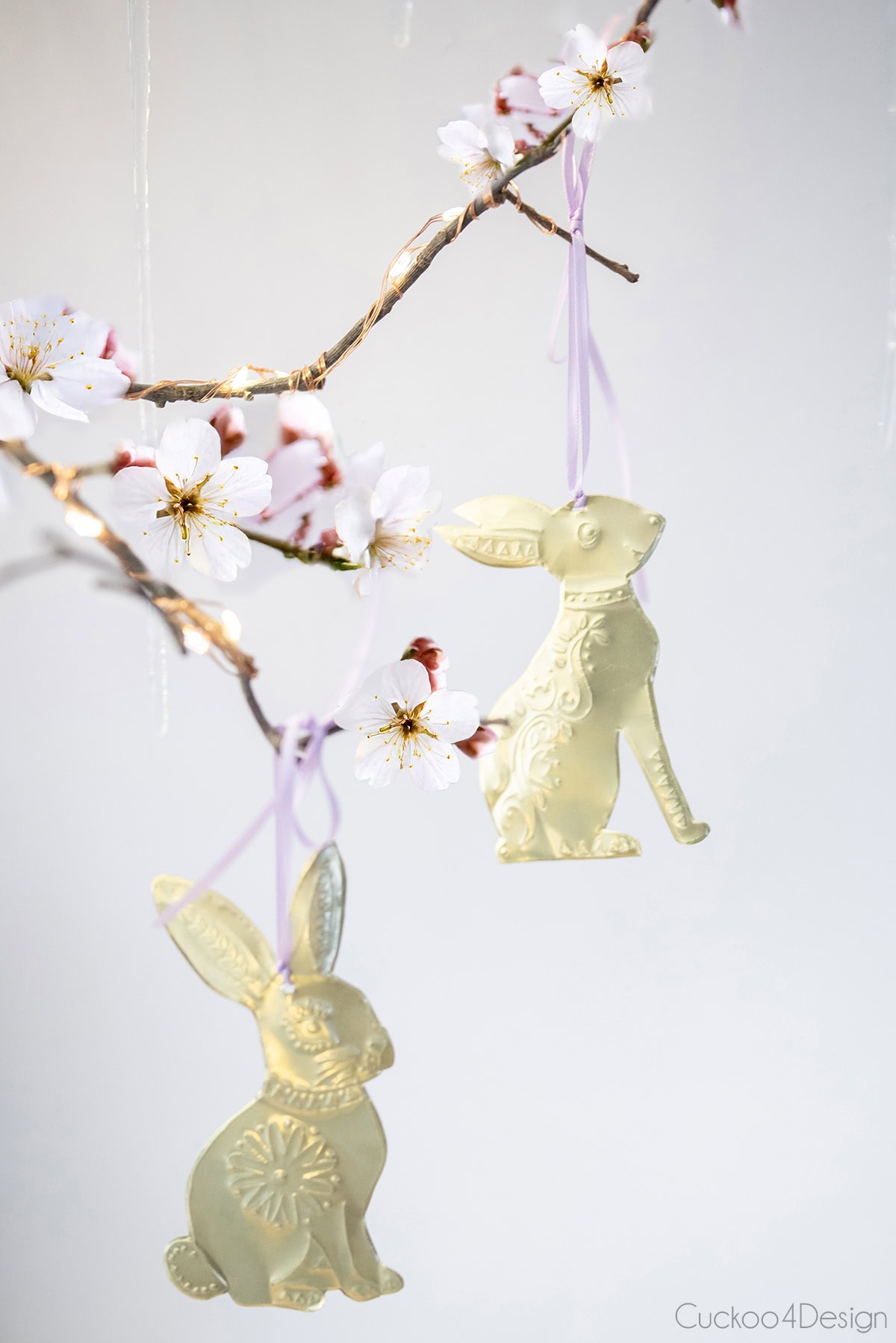 two Easter bunnies hanging on flowering branches