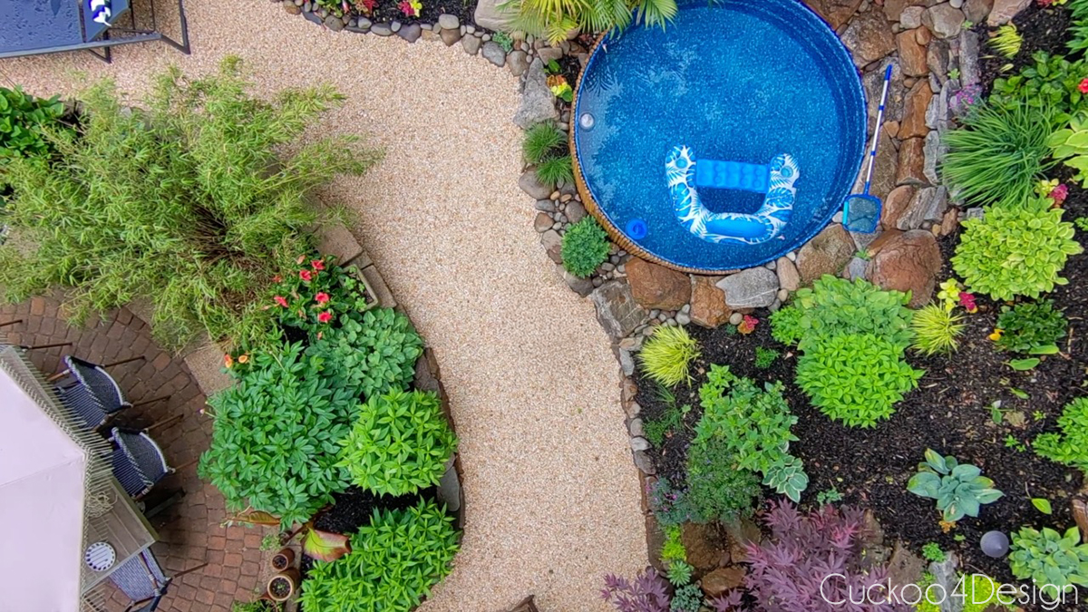 bird's-eye view of sotck tank pool, pea gravel path, and landscaping