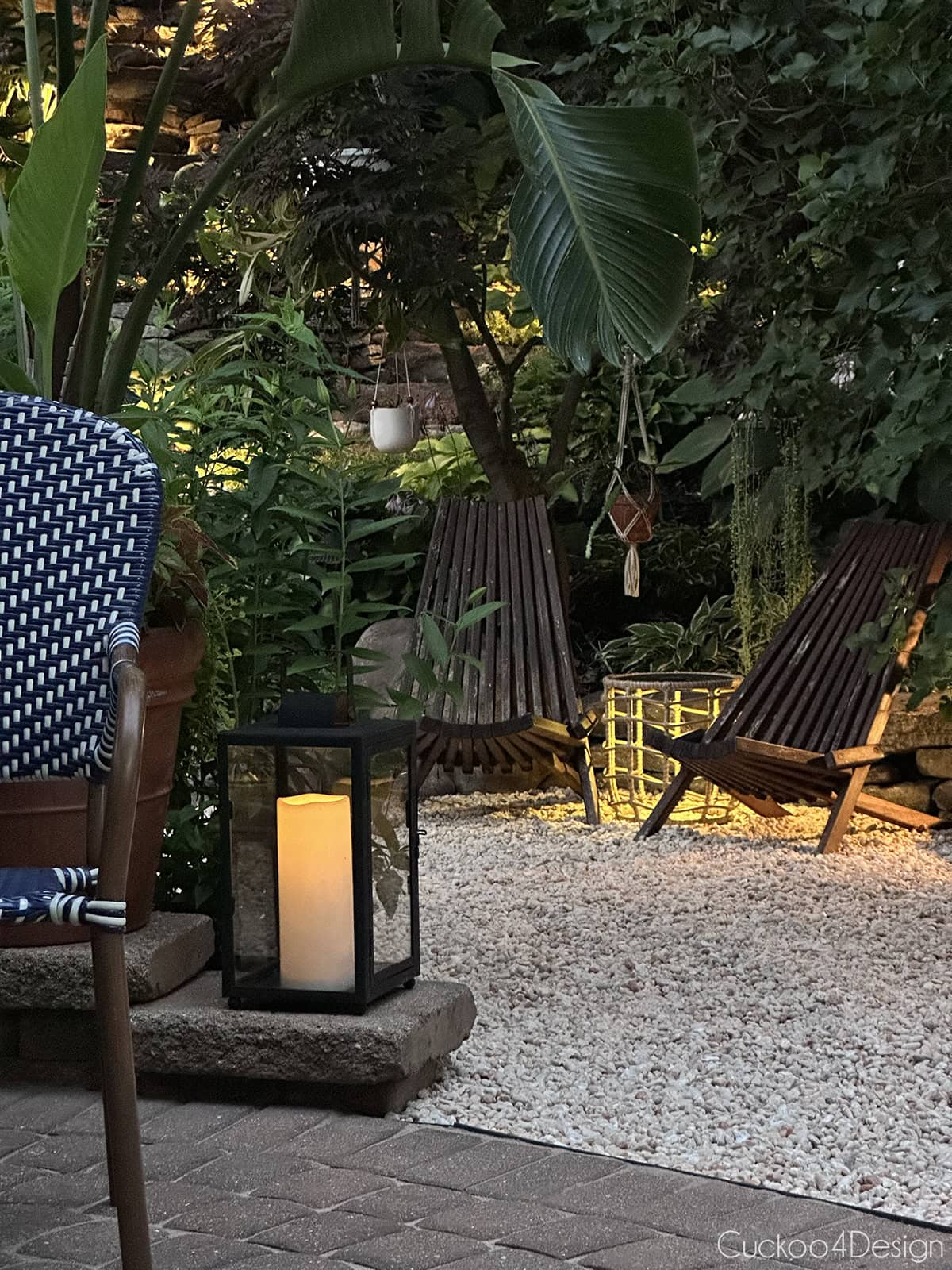 teak chairs on gravel at night with lighting and plants