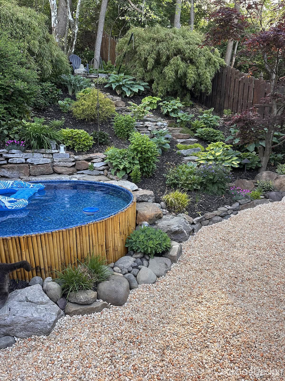 view of full backyard hill with landscape and pea gravel in front of the hill
