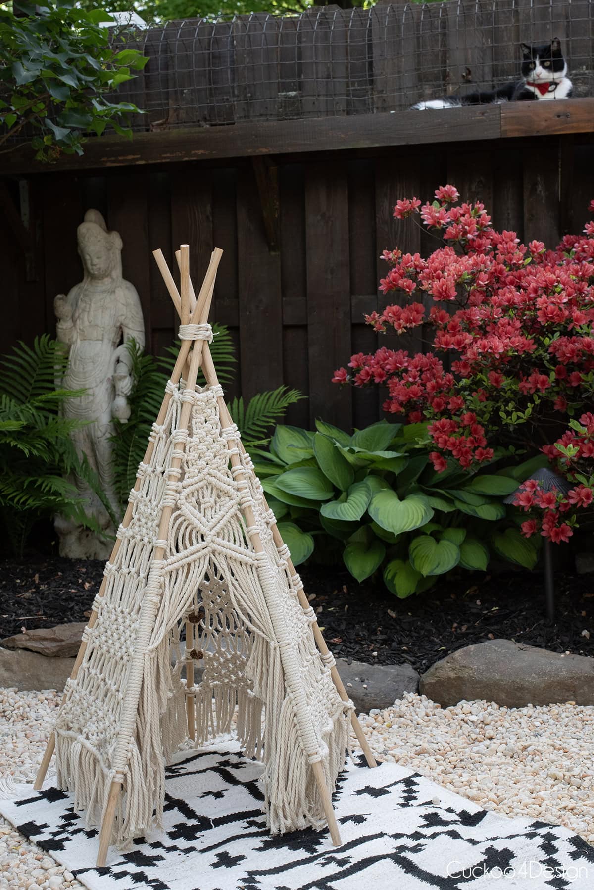 macrame teepee on pea gravel with fence and cat tunnel in the background