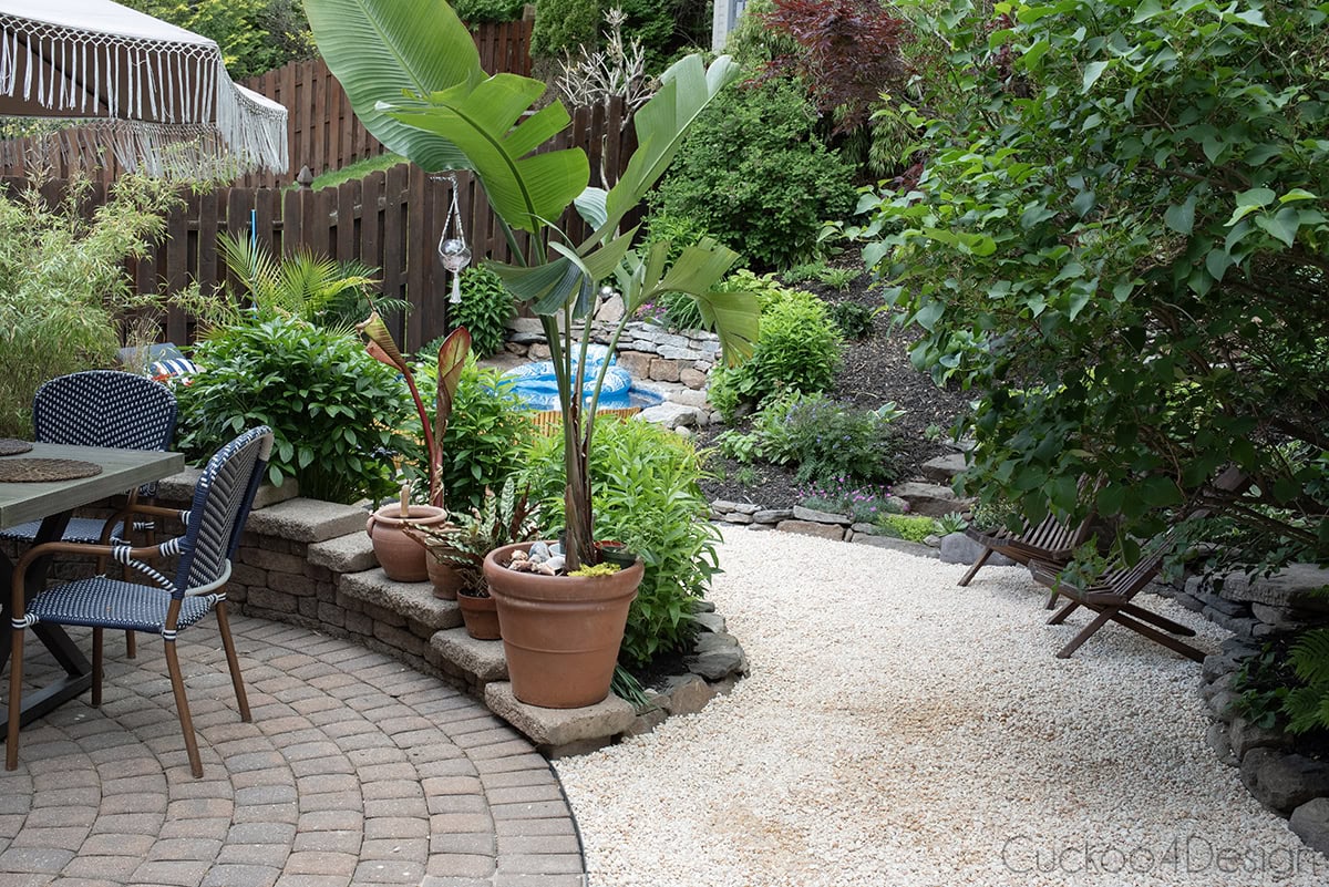 partial view of paver patio with stock tank pool in the background and pea gravel walkway