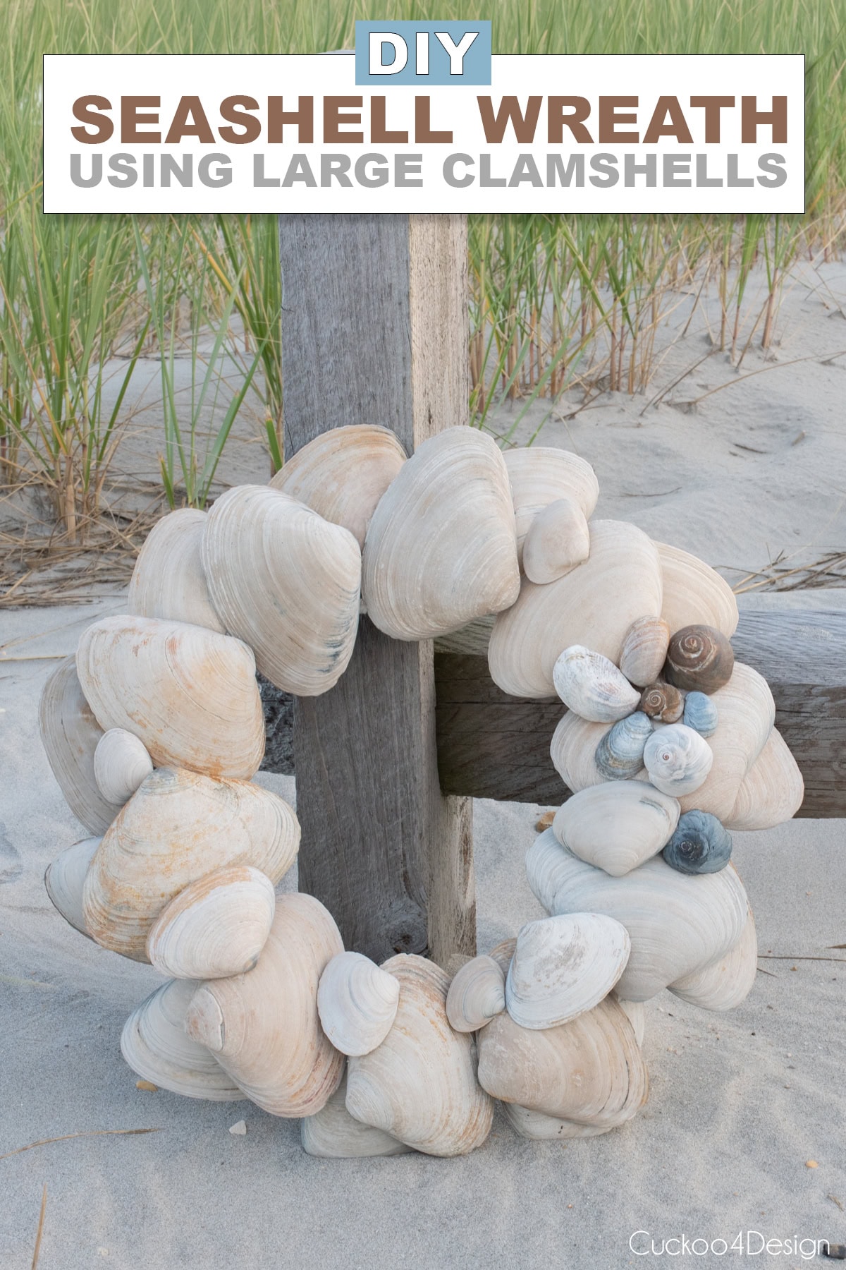 DIY seashell wreath with large clam shells and snail shell cluster on a driftwood fence
