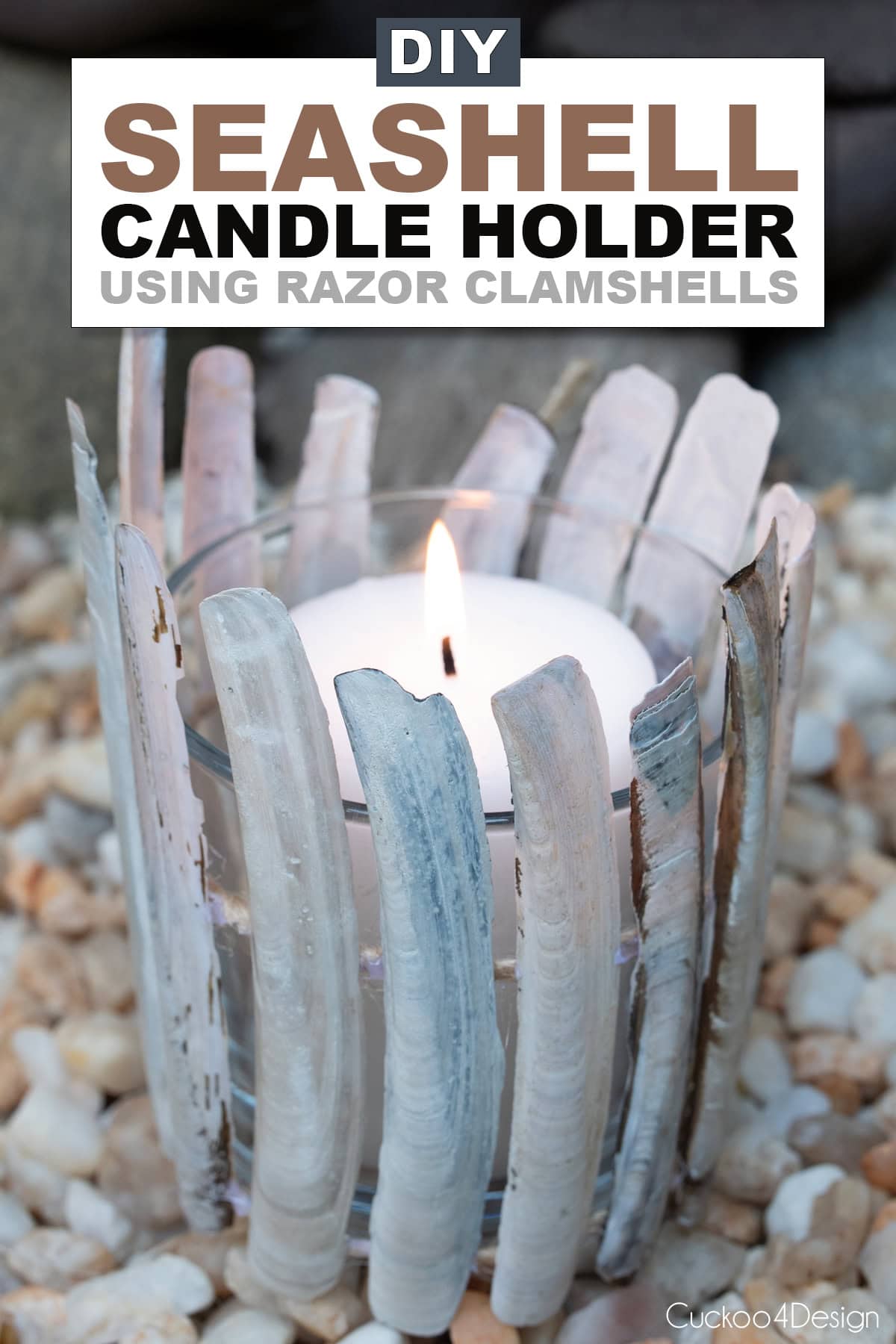 DIY seashell candle holder using razor clamshells on jute yarn, with lit candle, surrounded by beach pebbles