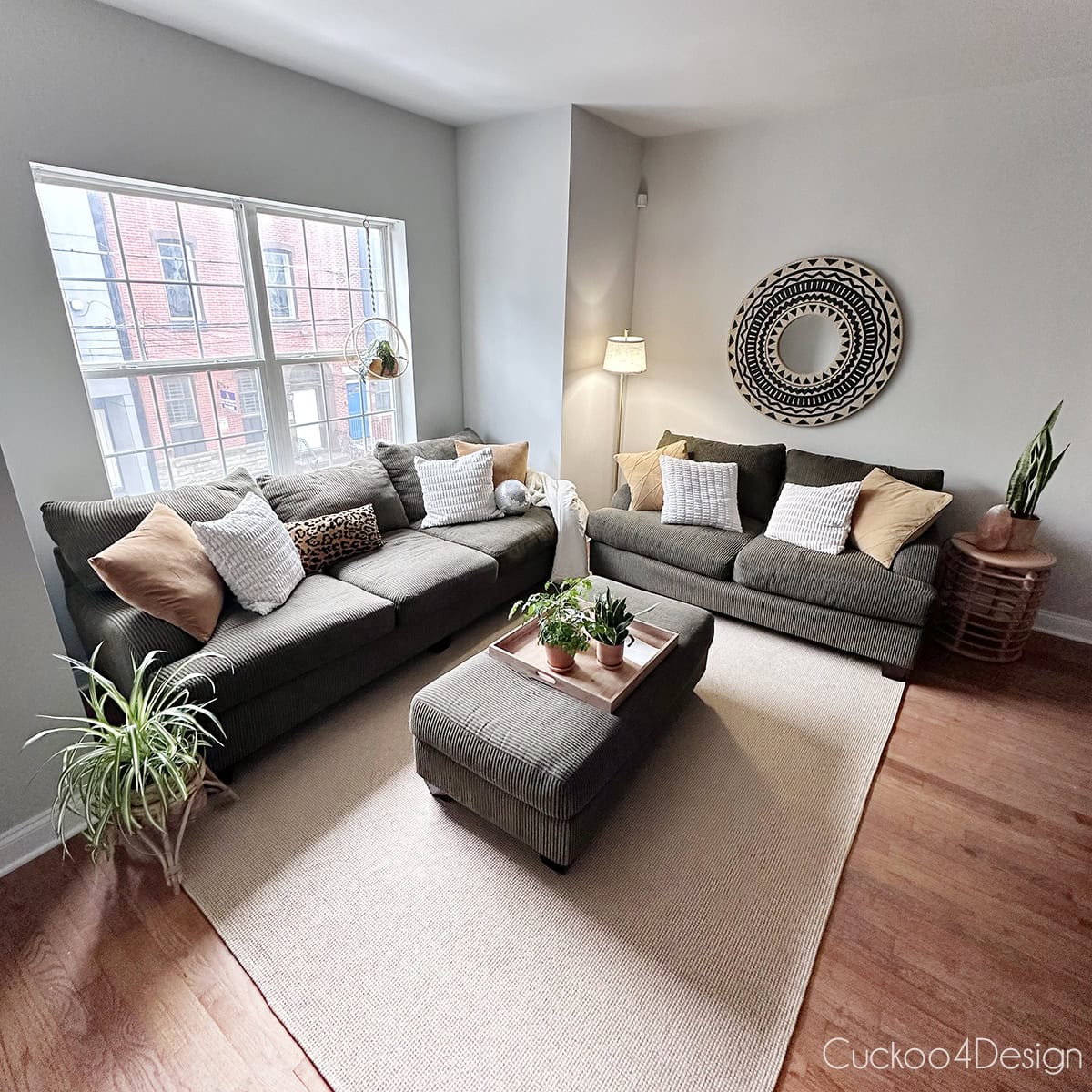discontinued fixed-frame Raymour & Flanigan Maverick sofa styled in a college apartment with Aztec embroidered wall mirror above