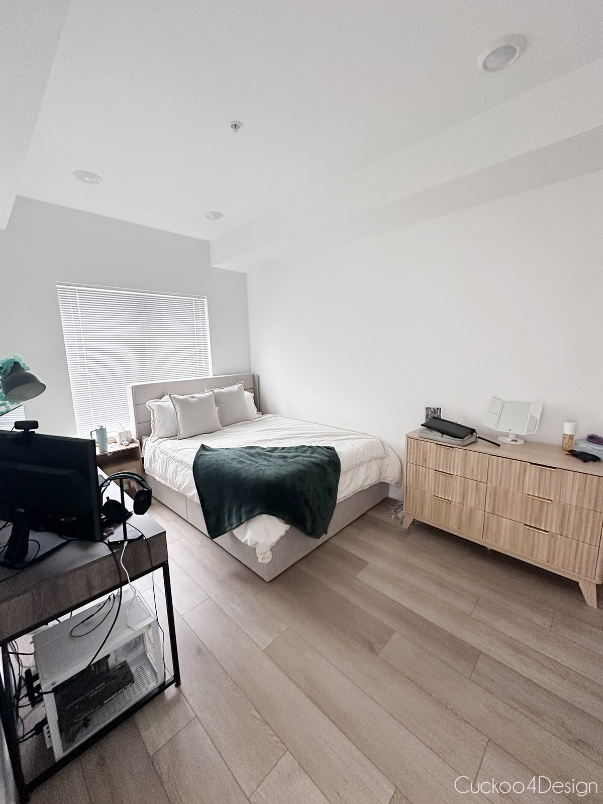 bedroom with an upholstered platform bed, green throw blanket, and wood dresser in a one bedroom Philadelphia apartment.