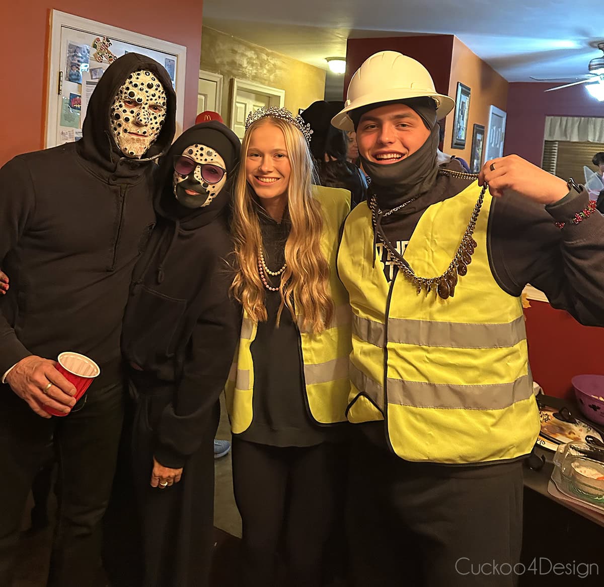 four people dressed up for Halloween with one couple as jewelry thieves and the other couple with googly eye makeup faces
