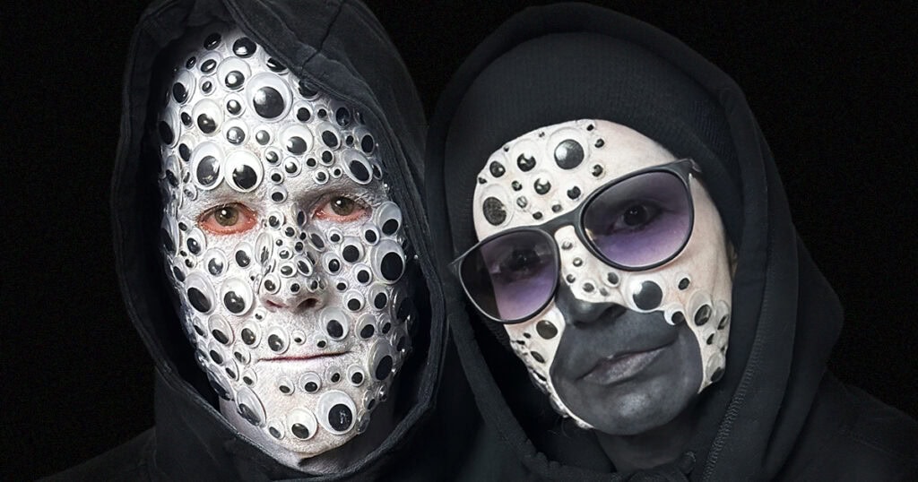 two people wearing black outfits, with one person having a full face of googly eyes glued to the face and the other having half of the face with googly eyes on a black background