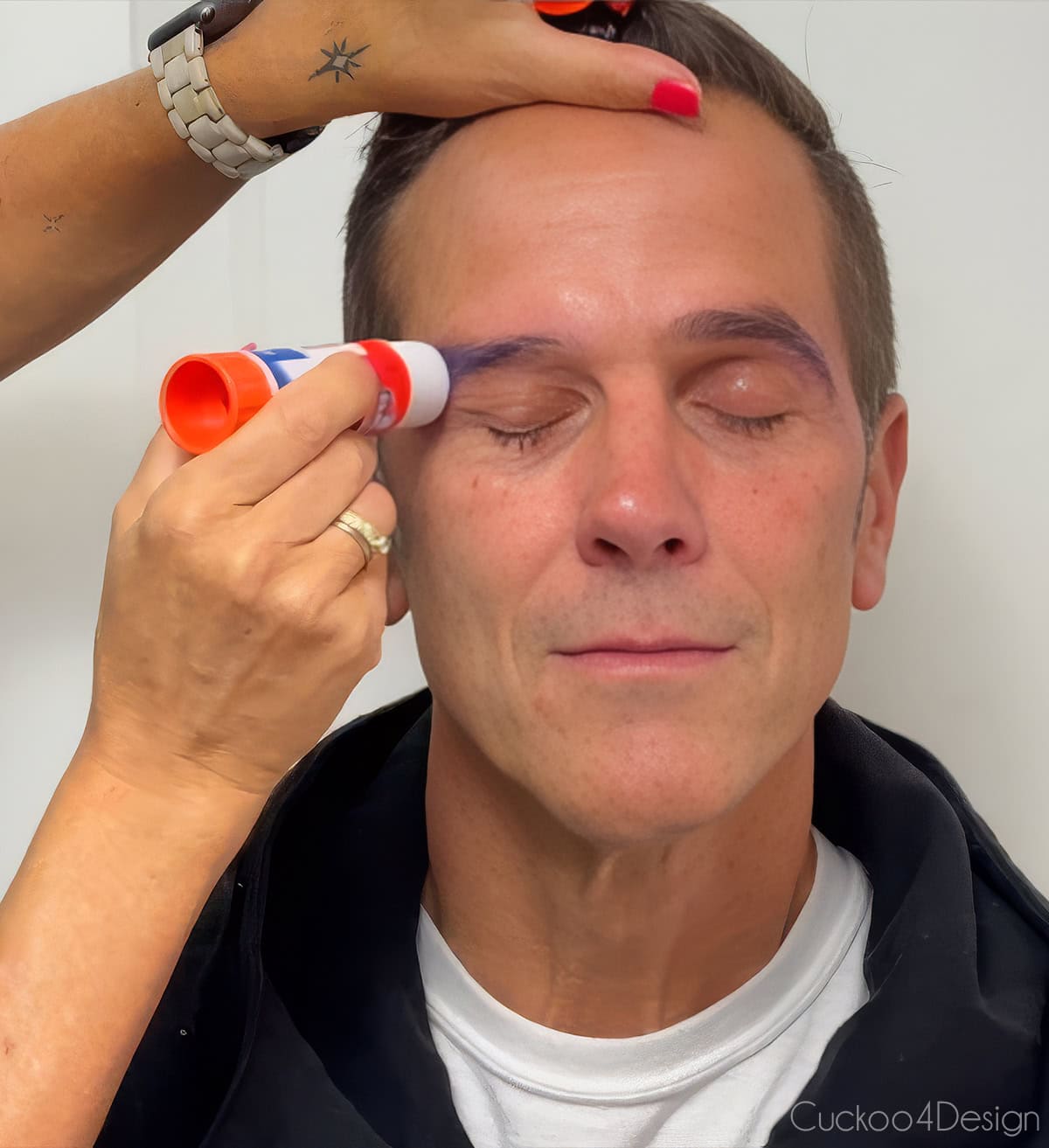 using a glue stick to glue down facial hair like eyebrows or sideburns on a man
