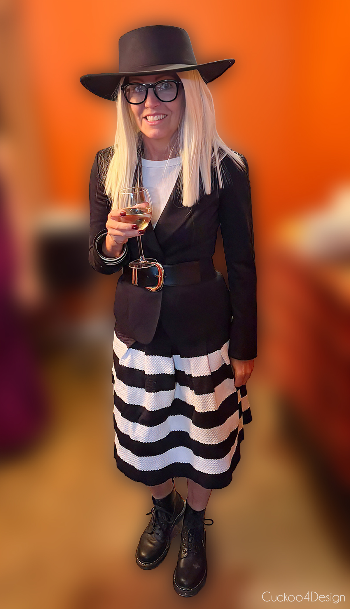 dead celebrities costume of Diane Keaton with a black hat, glasses, black blazer, black and white striped skirt, and black boots
