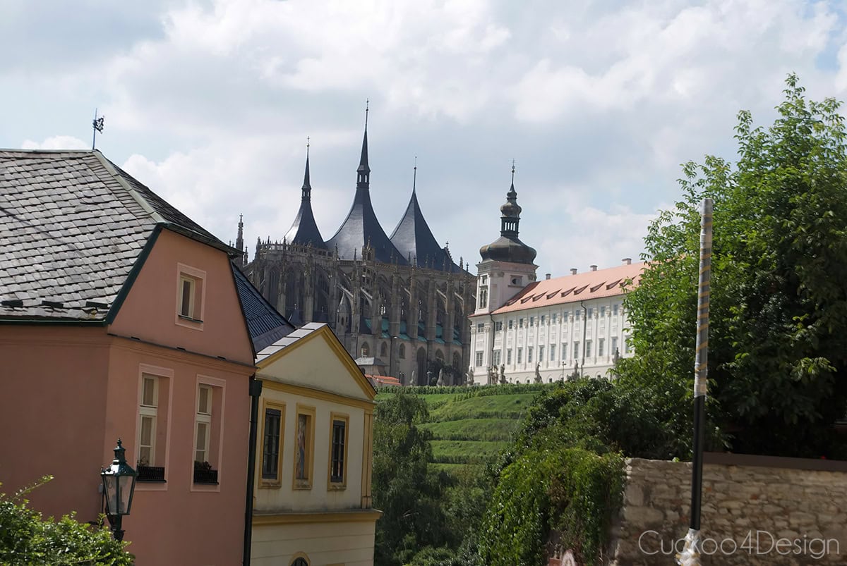 St. Barbara’s Church and the Jesuit College above a vineyard in Kutná Hora, seen past colorful old town houses