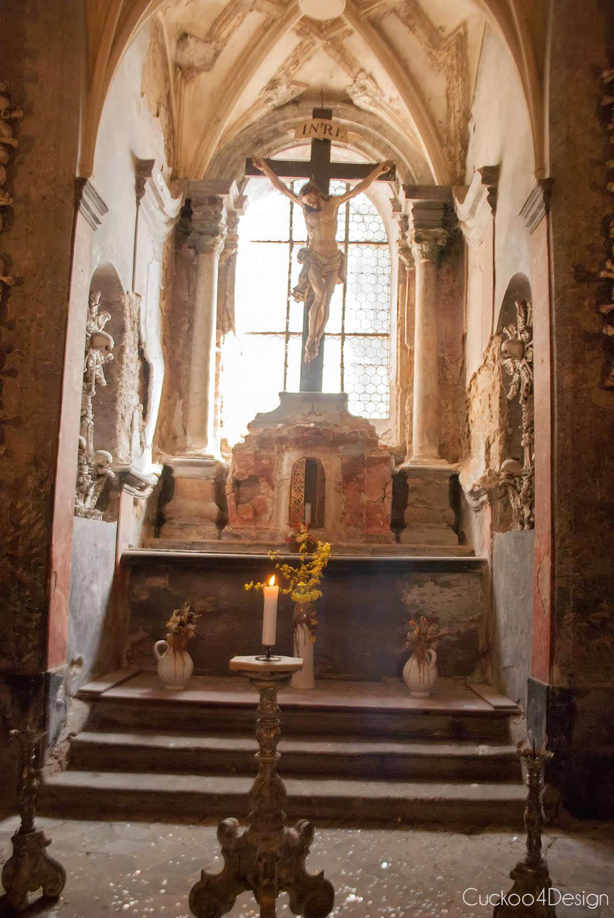 Altar with a crucifix and a lit candle inside the Sedlec Ossuary chapel